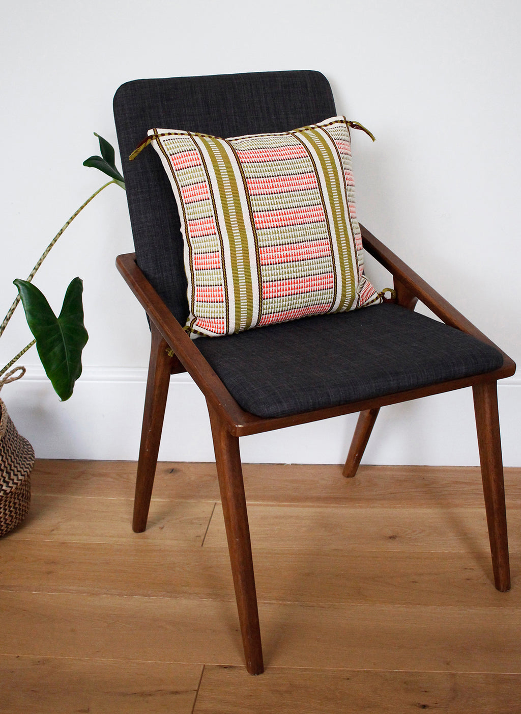 Handwoven cushion with green and coral pattern