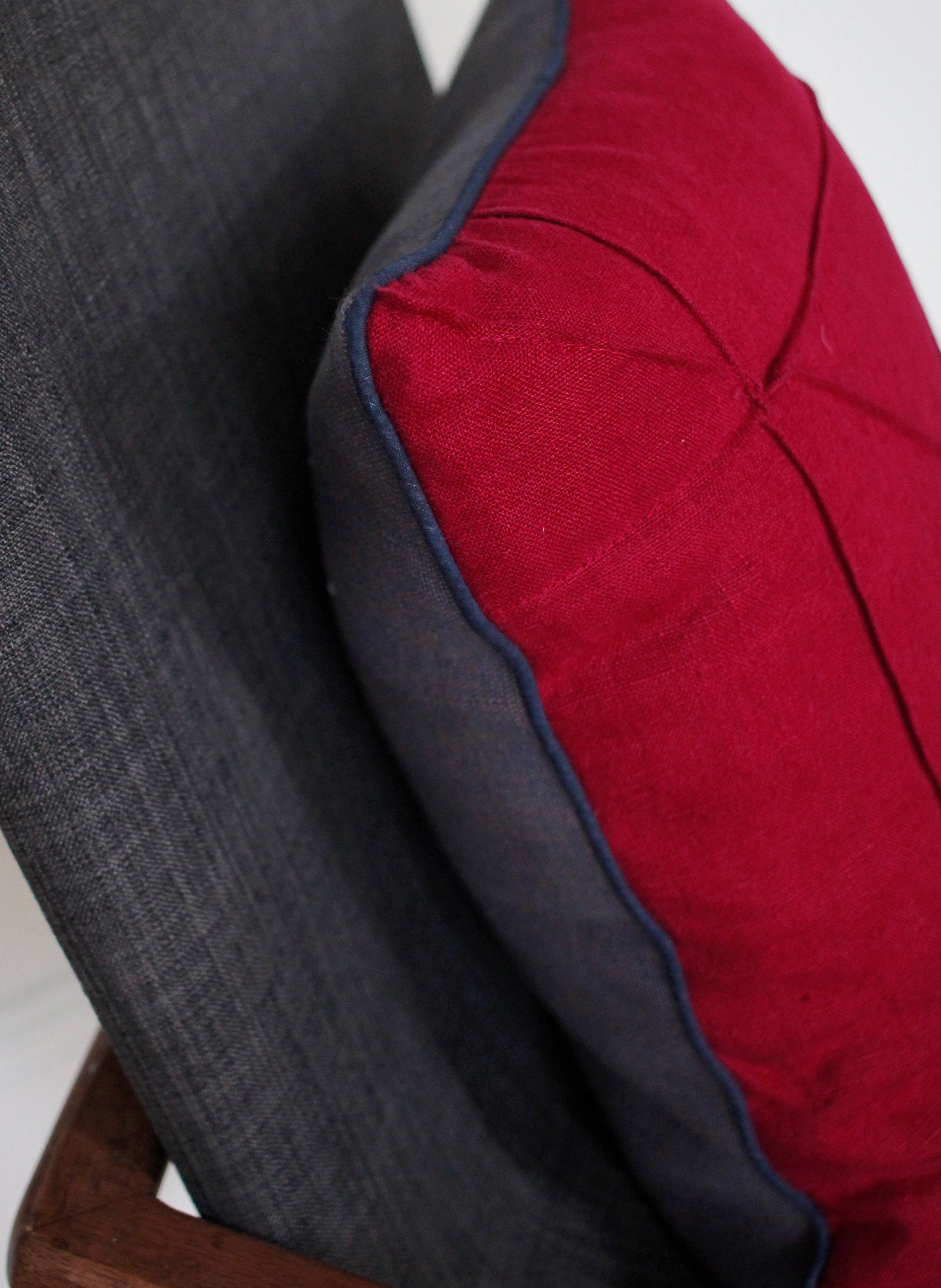 Blue piping detail on cranberry linen cushion