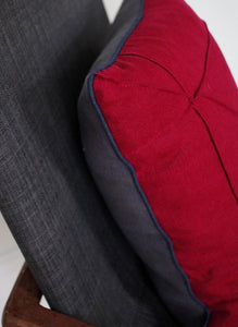 Blue piping detail on cranberry linen cushion