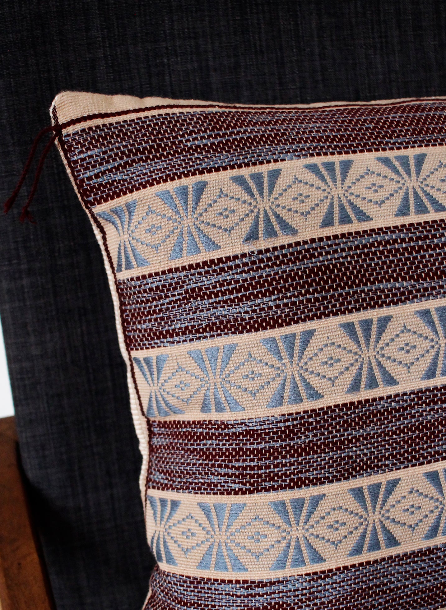 Corner detail of maroon pattern handwoven cushion
